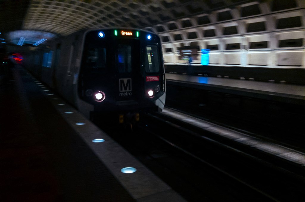 a subway train pulling into a subway station at night