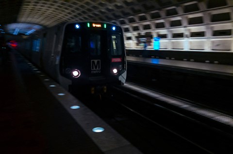 a subway train pulling into a subway station at night