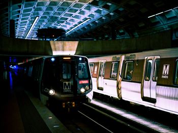 a subway train pulling into a subway station at night