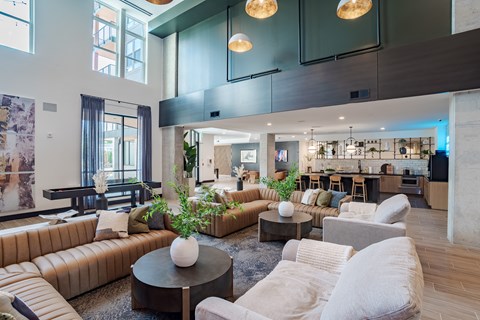 A modern living room with a brown leather couch and a coffee table with a white vase on it.