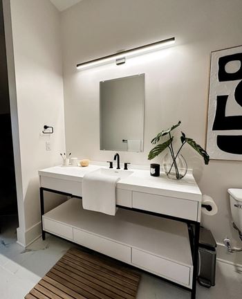 A white bathroom with a sink and mirror.