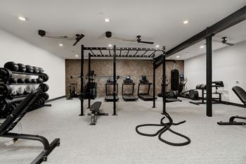 A gym with a variety of equipment including weights and a bench.