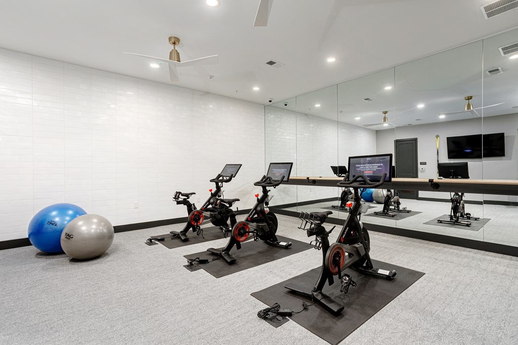 A gym with exercise bikes and a television.