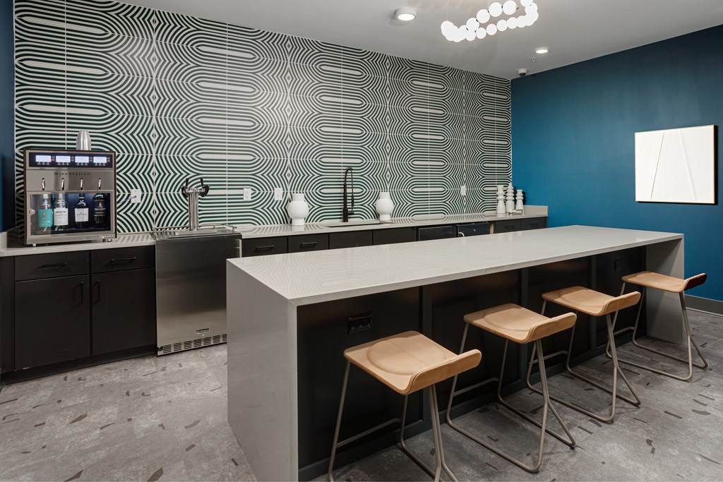 A modern kitchen with a bar area and stools.