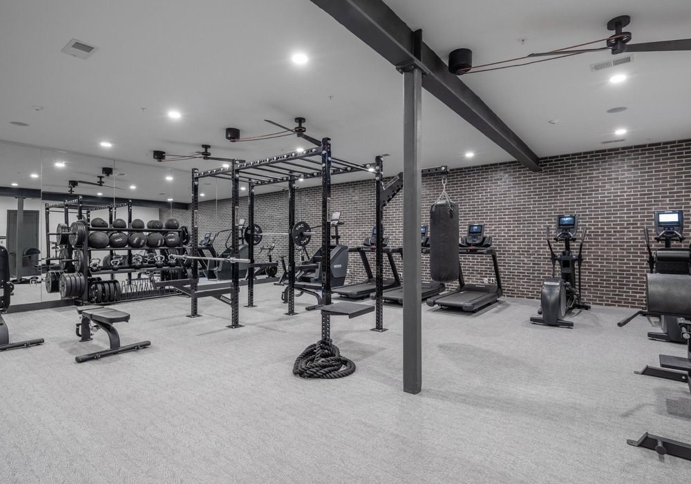 A well-equipped gym with various exercise machines and weights.