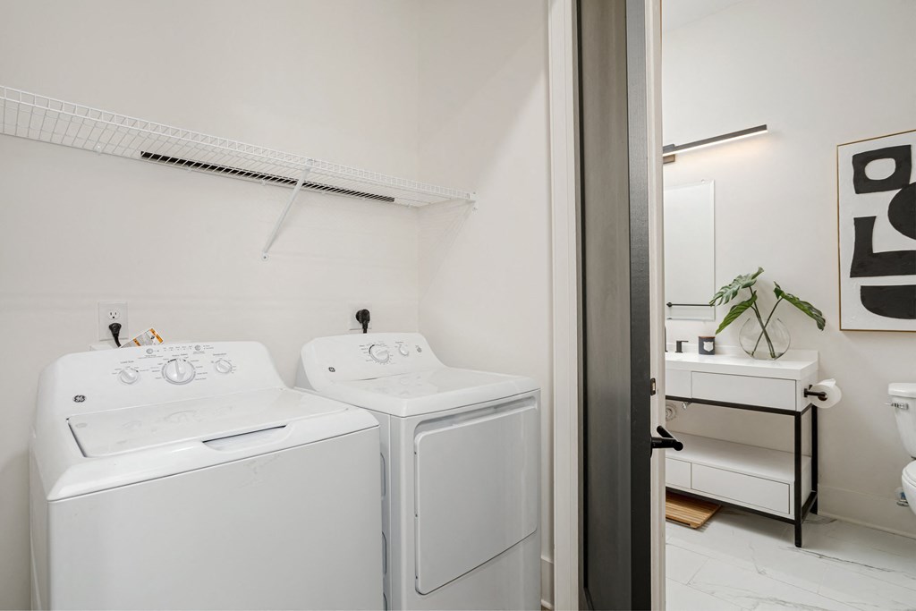 A white washing machine and dryer in a laundry room at Vintage Edge Nashville Apartments, Tennessee