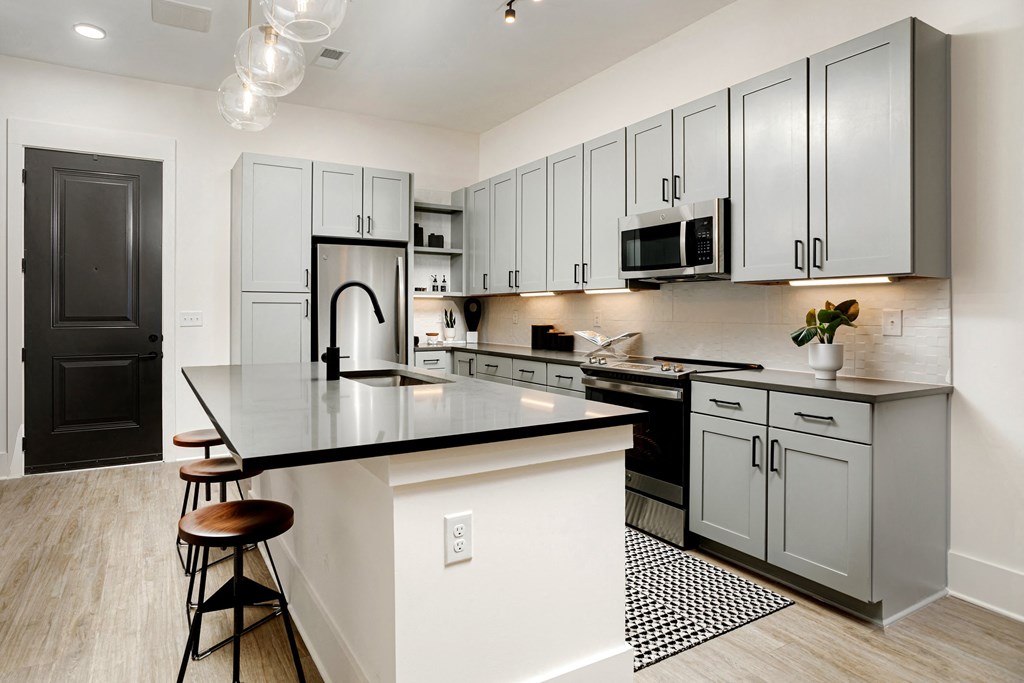 A kitchen with a black countertop and white cabinets at Vintage Edge Nashville Apartments, Nashville