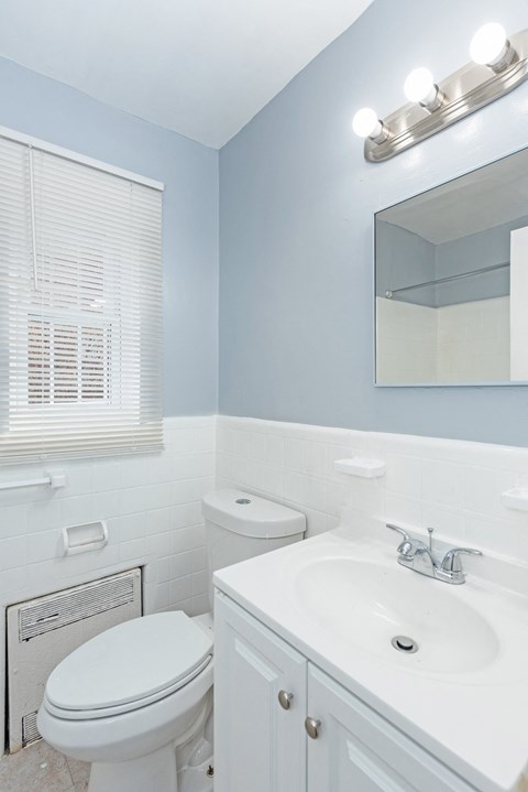 a bathroom with a toilet sink and mirror