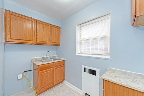 A kitchen with wooden cabinets and a white sink.