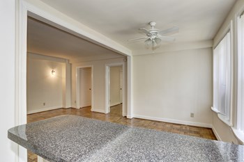 room with ceiling fan, stone counter, wood floors and white walls at Tivoli Gardens Apartments in Washington, DC