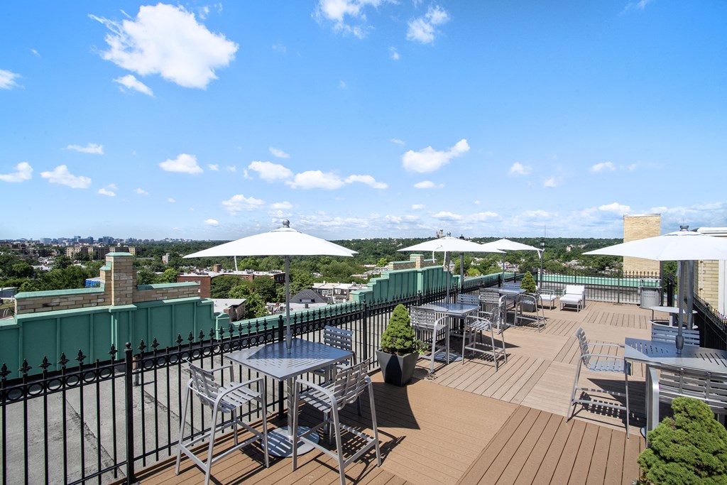 the rooftop terrace of the hotel has tables with umbrellas and chairs