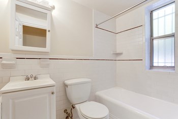 bathroom with white tile and tub at Tivoli Gardens Apartments in Washington, DC