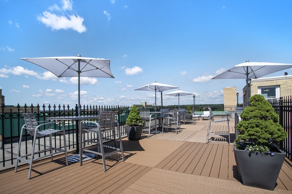 a roof top patio with tables and chairs and umbrellas
