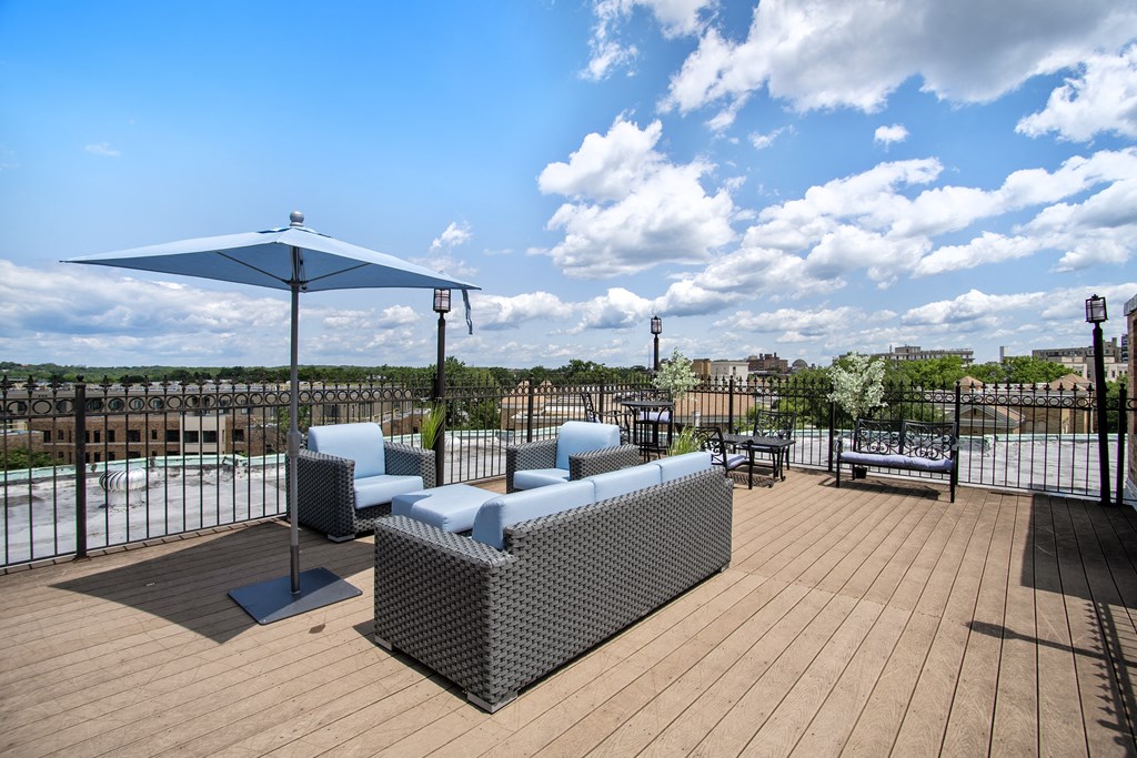 a rooftop patio with couches and an umbrella and a pool at Park Terrace, Washington