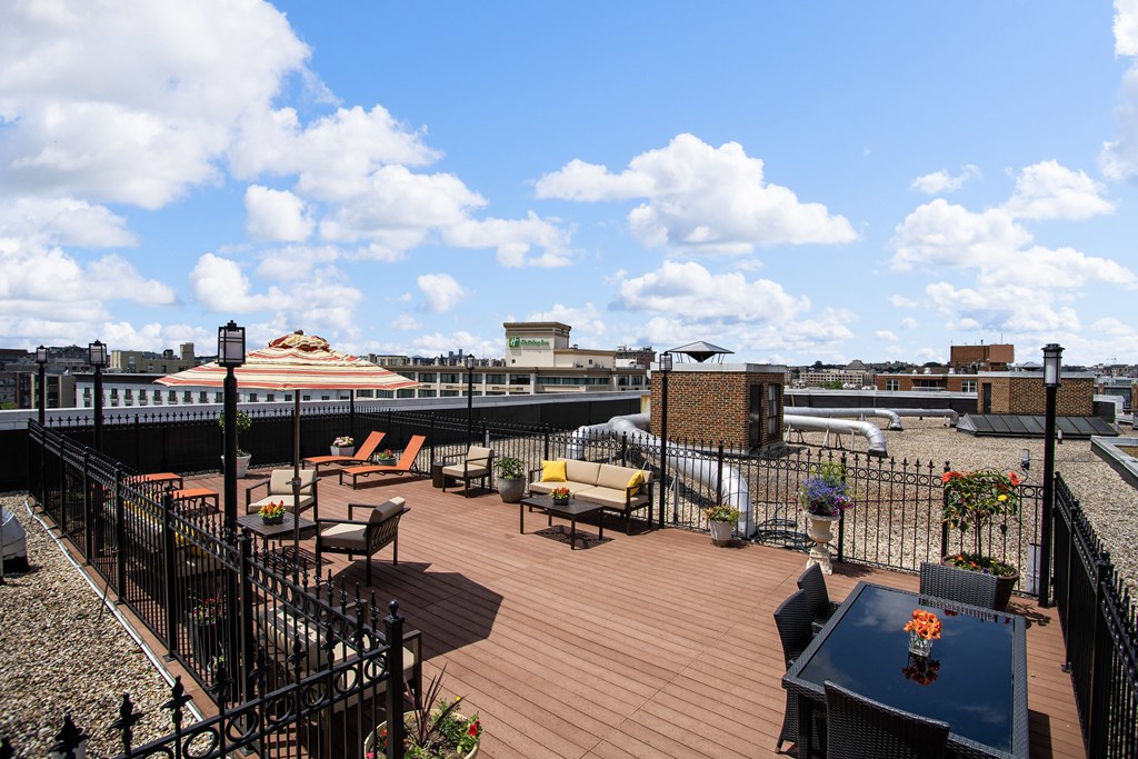 a roof deck with furniture and a view of the city