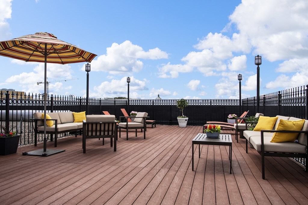 a deck with chairs and umbrellas on top of a roof