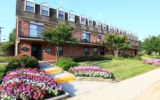 A brick building with a flower bed in front.