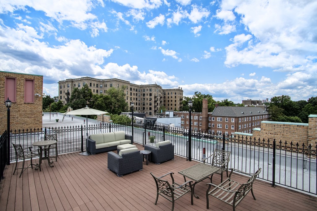 a rooftop deck with furniture and a pool