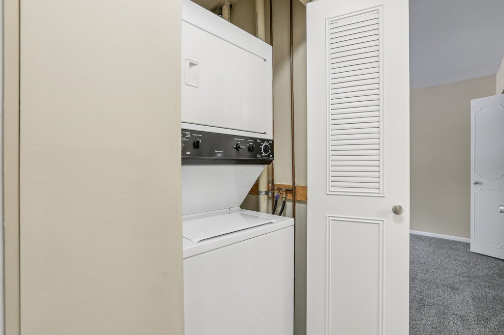 A white oven and microwave are built into a wall.