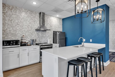 A kitchen with a white countertop and black stools.
