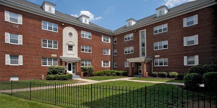 A red brick building with a black fence at University Landing Apartments, Silver Spring