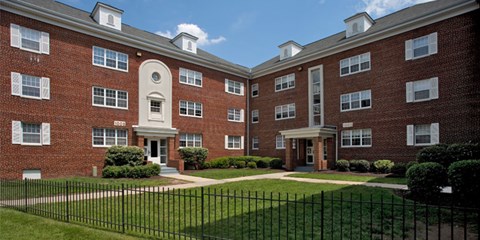 A red brick building with a black fence at University Landing Apartments, Silver Spring