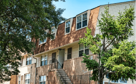 A brown building with a tree in front of it. A brown building with a tree in front of it at Pleasantview Apartments, Baltimore