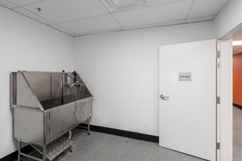 A large metal container sits in a white room next to a door.