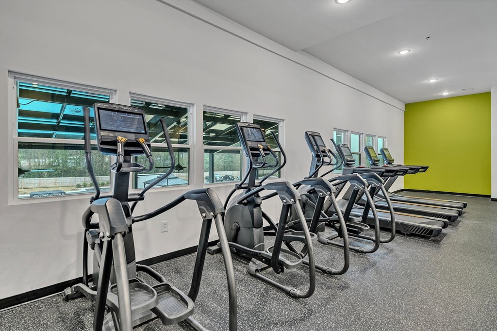 A gym with treadmills and elliptical machines.