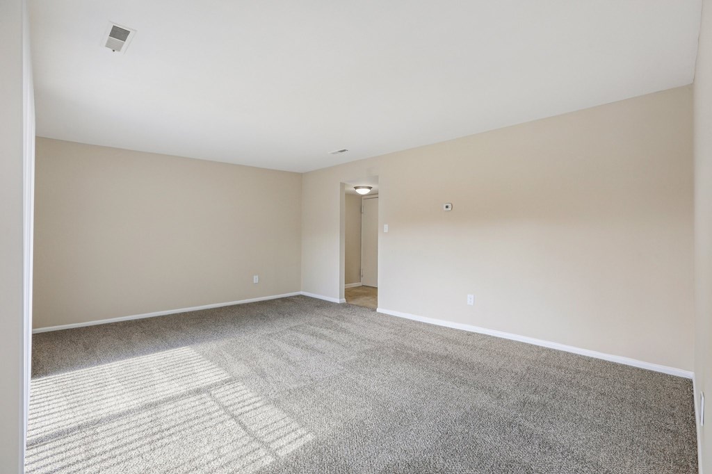 A room with a carpeted floor and a door in the middle.