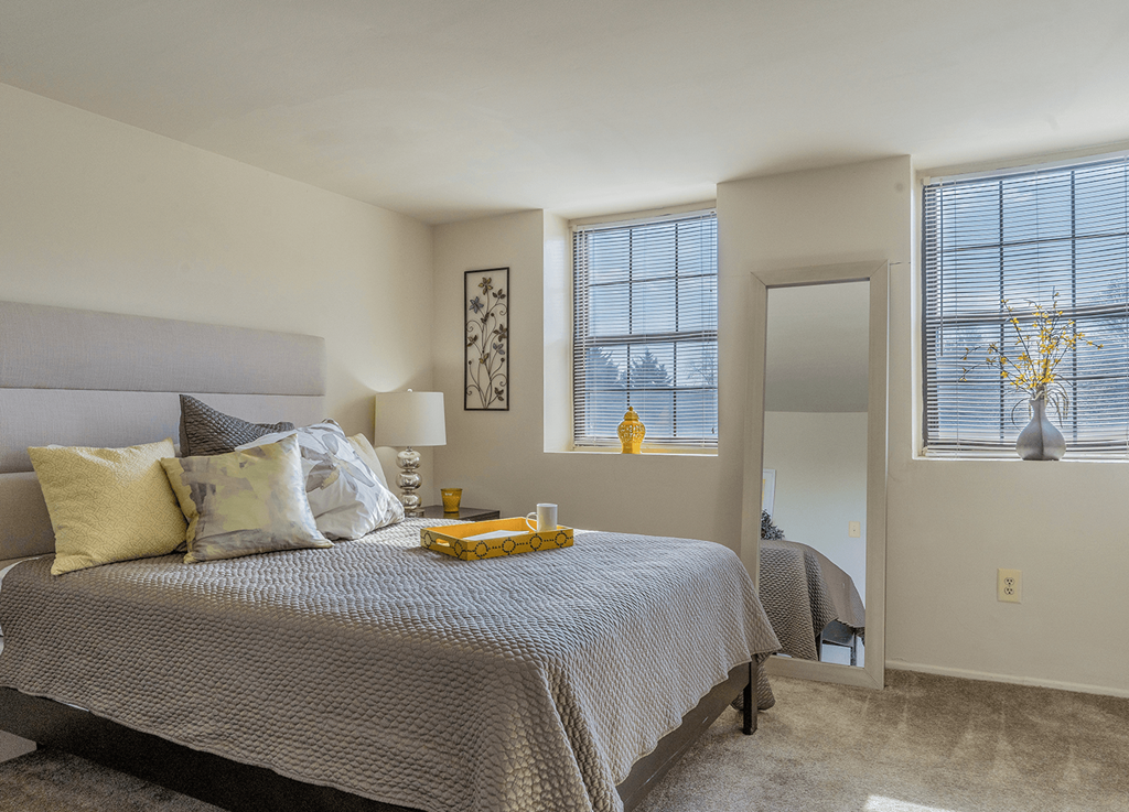 A bedroom with a large bed and a window with blinds. A bedroom with a large bed and a window with blinds at Dutch Village Apartments, Baltimore, MD, 21234