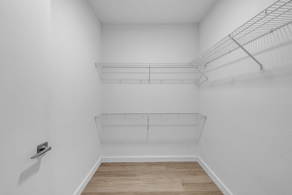 A white wall with a shelf and a light switch.