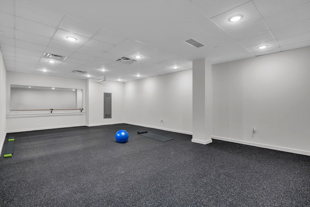 A blue ball is on the floor of a white room.