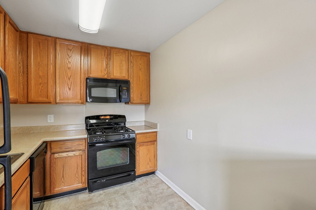 A kitchen with wooden cabinets and a black stove top oven.