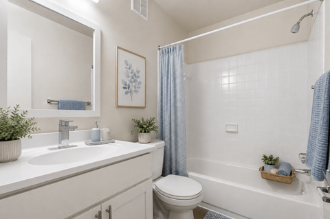 A white bathroom with a toilet, sink, and bathtub.