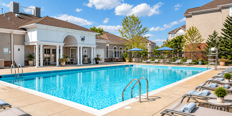 A large swimming pool with a white building in the background.