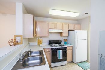 a small kitchen with white appliances and wooden cabinets