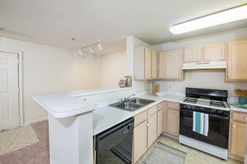 a kitchen with white counter tops and black appliances