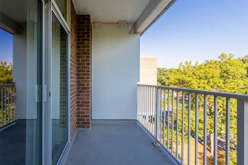 A balcony with a glass door and a metal railing.