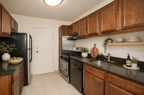 A kitchen with black appliances and wooden cabinets.