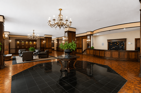 A large room with a black table in the middle and a chandelier hanging from the ceiling.
