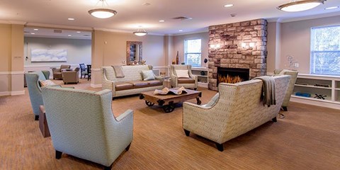 A living room with a stone fireplace and a large couch.