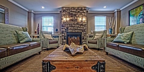 A living room with a stone fireplace and two couches.
