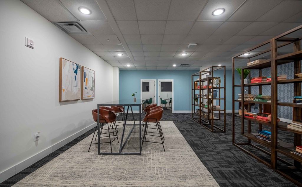 A room with a table, chairs, and bookshelves.