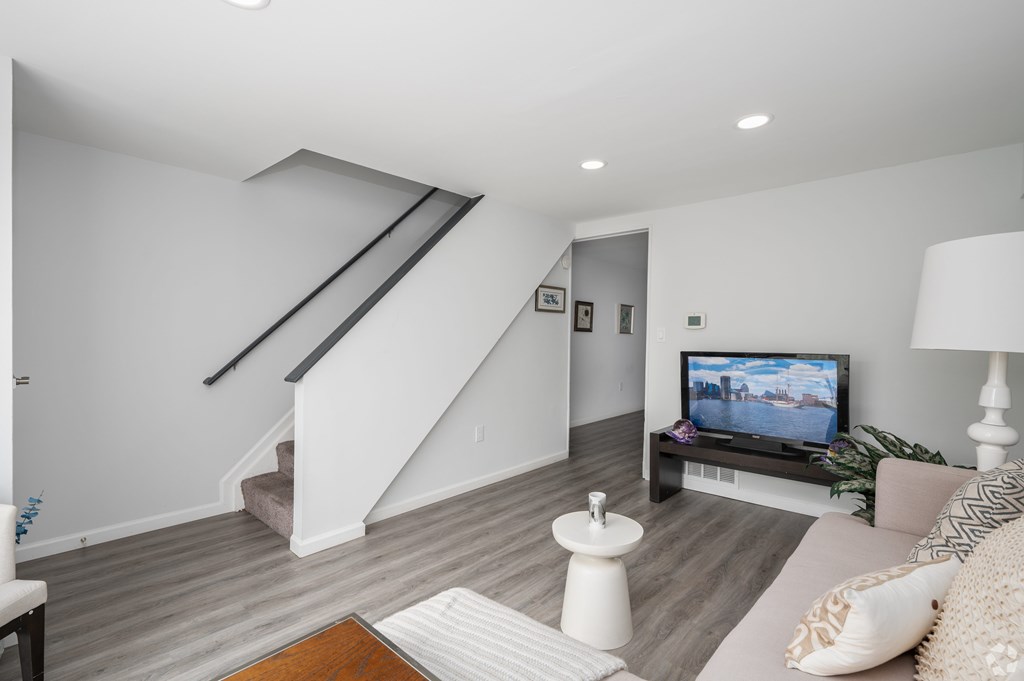 A living room with a television and a staircase.