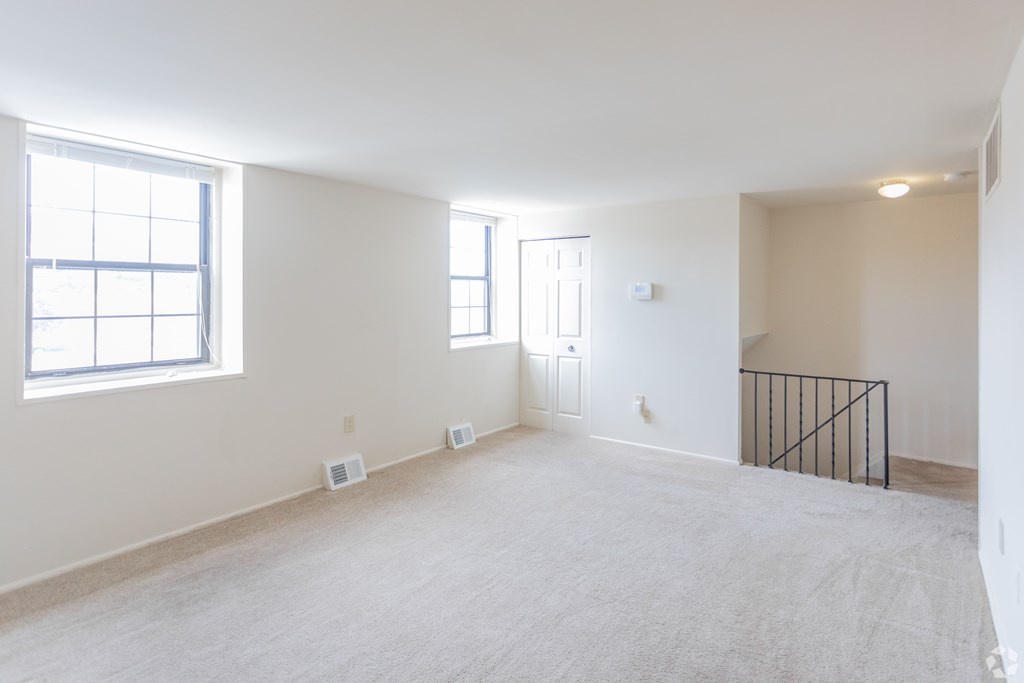 A large empty room with a window and a door.