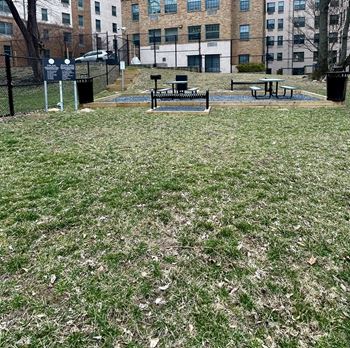 Grassy area with a picnic table and a fence at Tivoli Gardens, Washington, DC