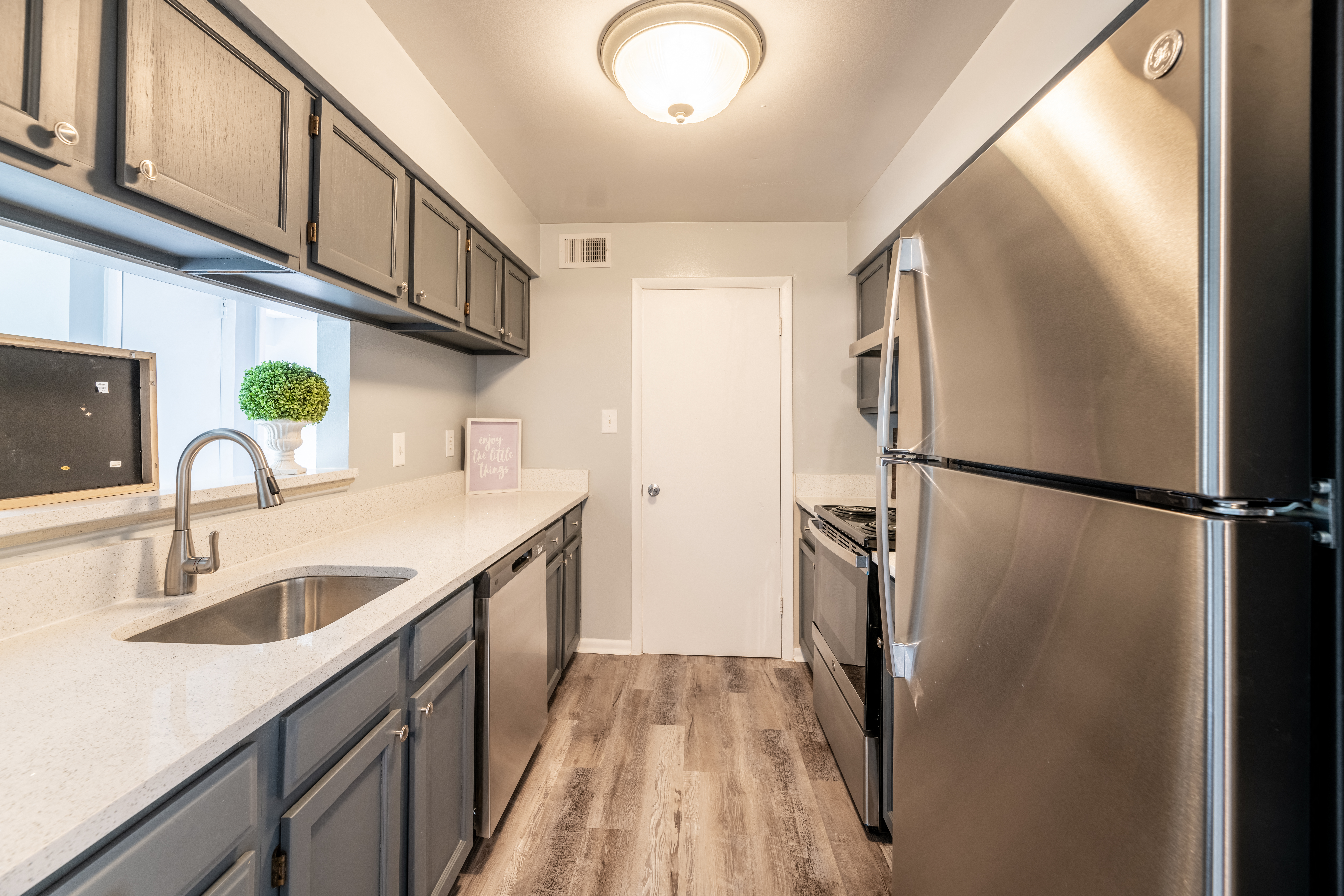 a kitchen with stainless steel appliances and a sink and a refrigerator