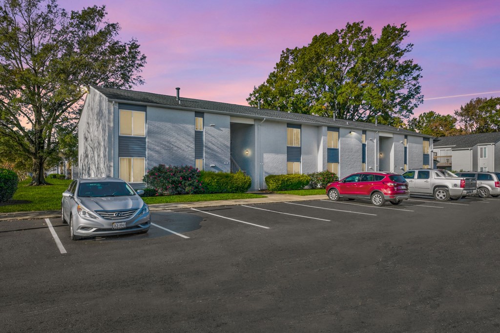 a parking lot with cars in front of a building