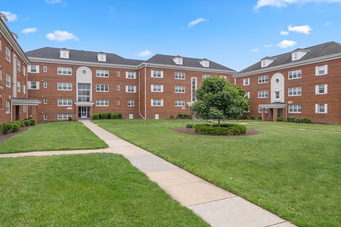 A large brick building with a tree in the front yard.